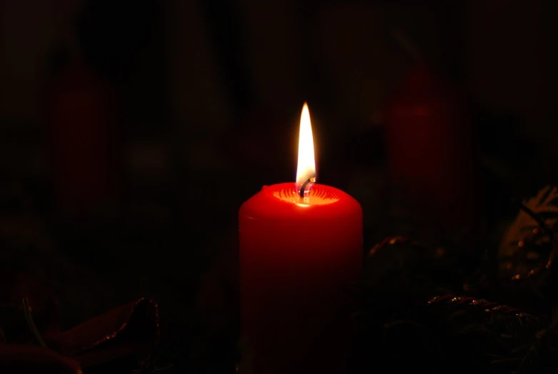 a red lit candle sitting on top of a table