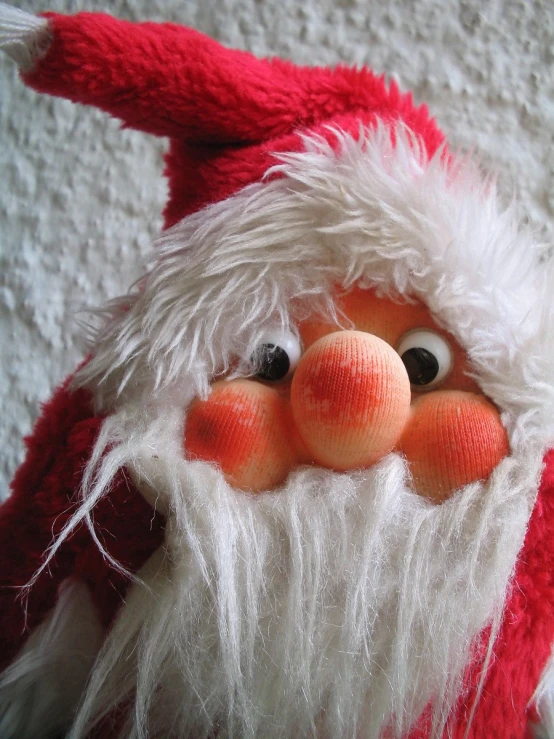 a close up of a stuffed santa claus wearing a red hat