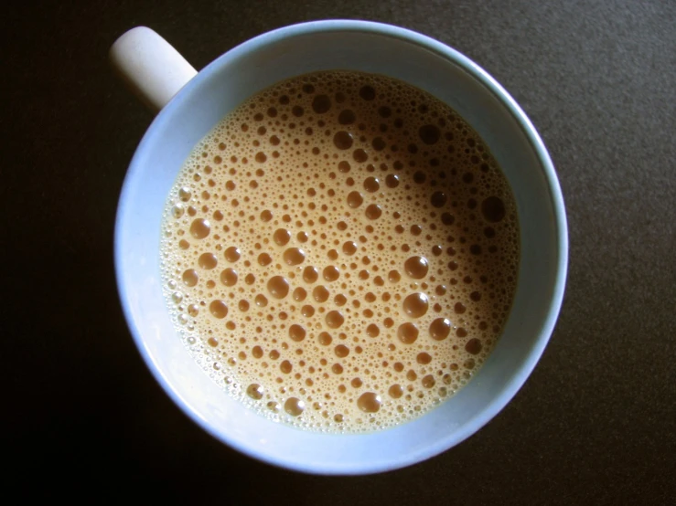 the cappuccino is in a blue bowl