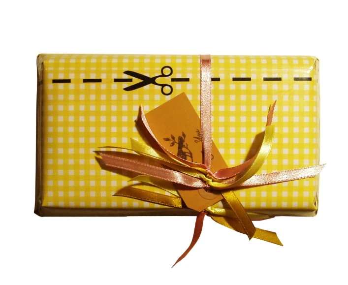 a yellow box with gold ribbon and scissors