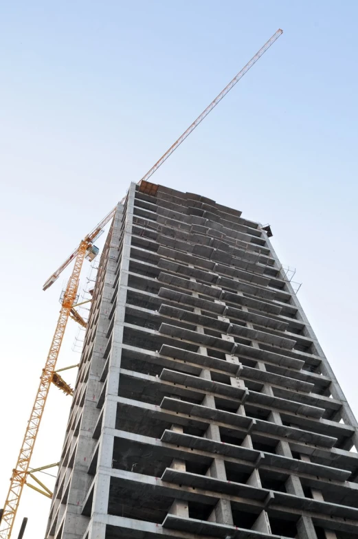 some construction cranes next to a tall building