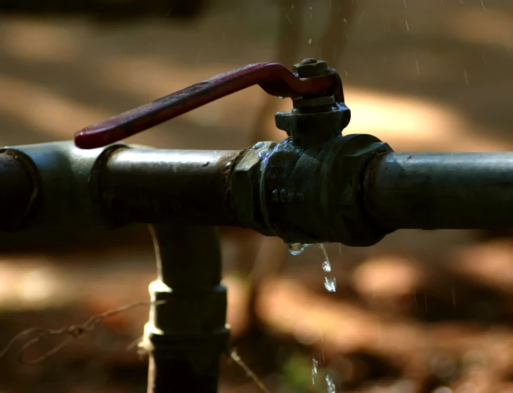 a tap from a metal pipe with water dripping