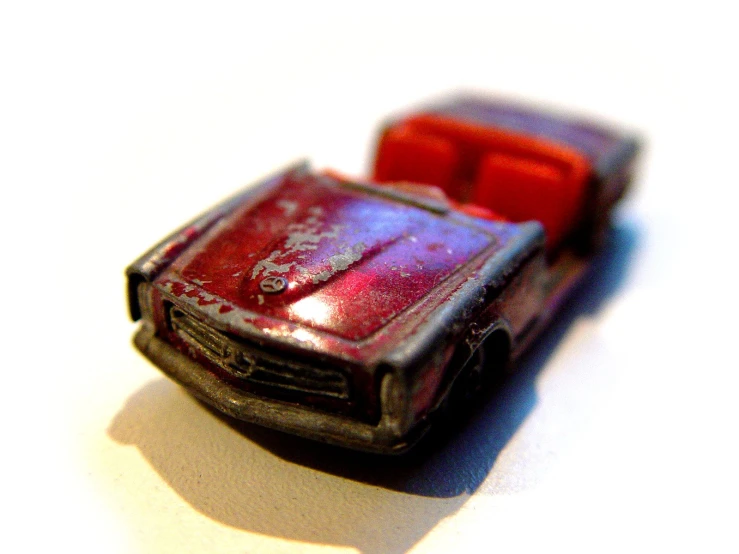 a toy car is painted red and purple