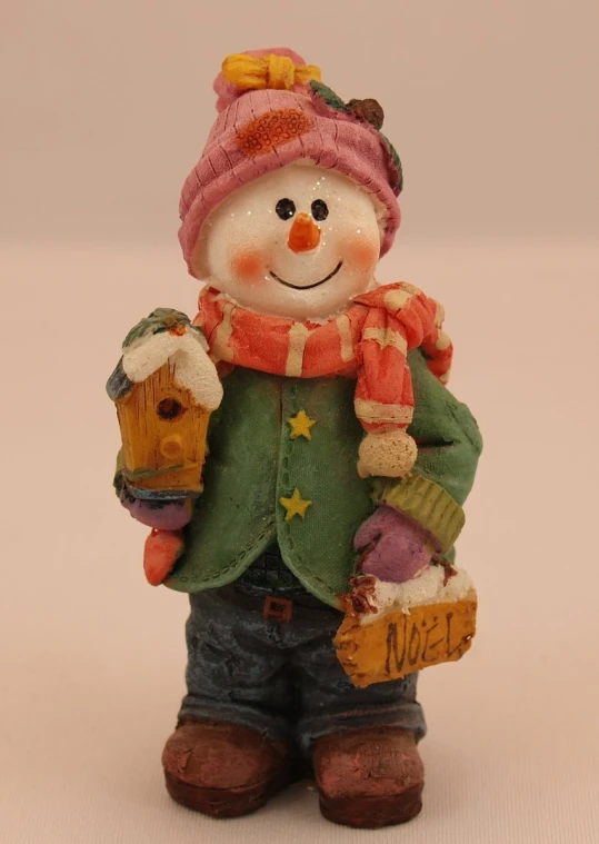this is a figurine of a snowman holding a sign