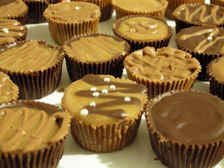 a large plate filled with chocolate cupcakes topped in peanut er