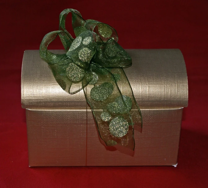 an artistically styled gift wrapped in shiny gold ribbon