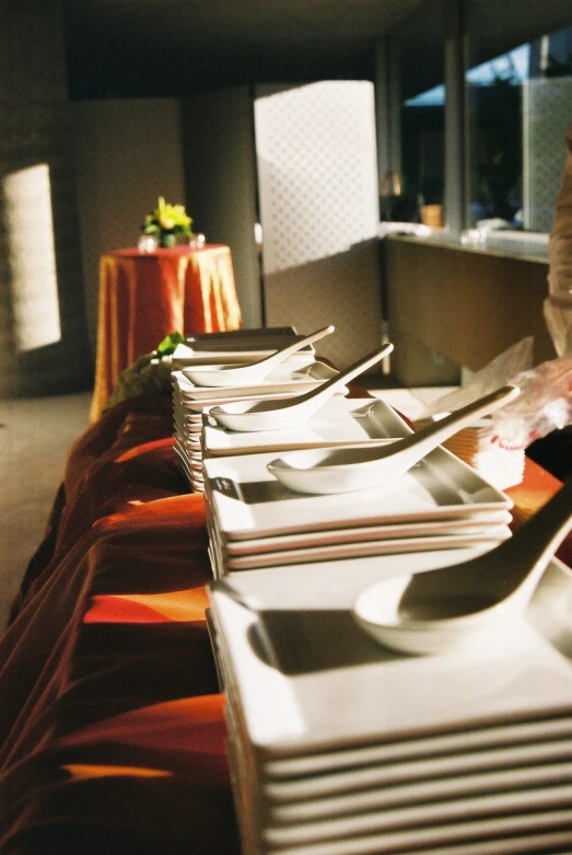 long row of silverware on wooden table at event