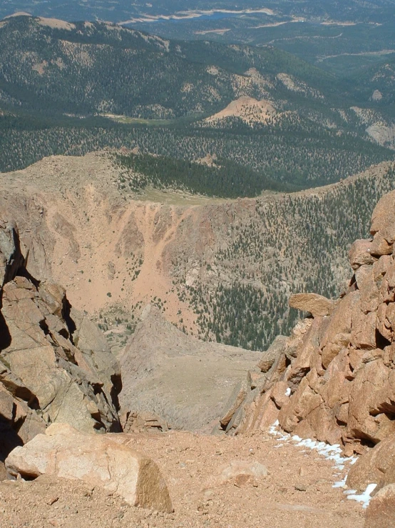 mountains and valleys are seen behind large rocks