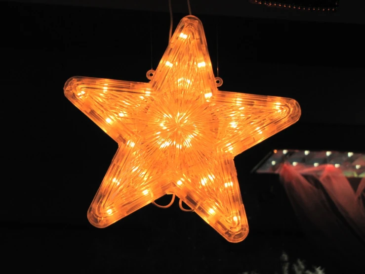 a large star shaped light hanging from a ceiling