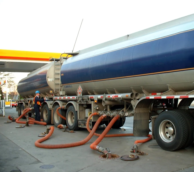 a big blue tanker truck with hoses attached to it