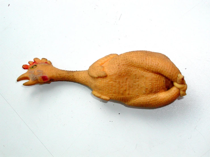 a figurine of an animal laying on a white surface