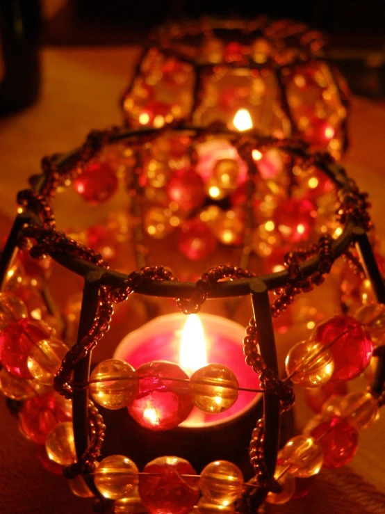 a lit candle in a candle holder with beads