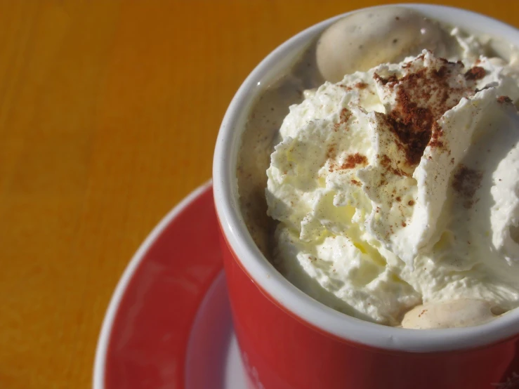 a red cup of white chocolate covered with whipped cream