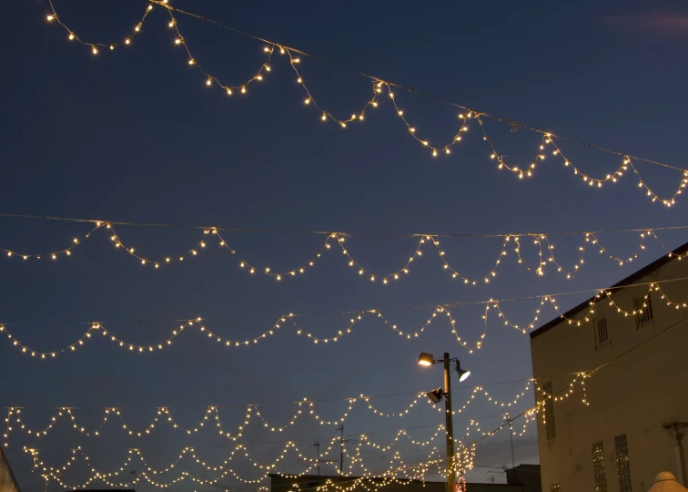 a night time scene with lights strung across the street