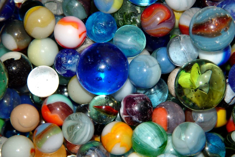 a collection of marbles sit together in a pile