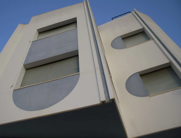 two building facade with round windows and a sky background