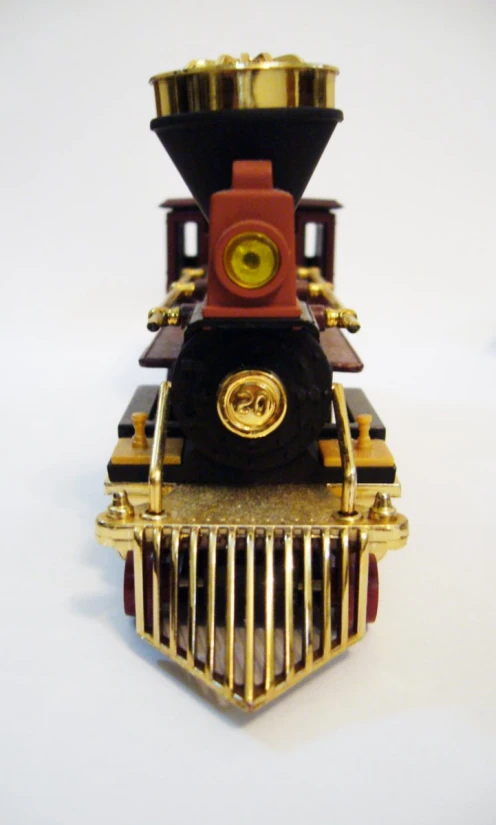 a gold and red train sculpture on white surface