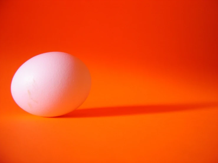 the egg is sitting on an orange surface