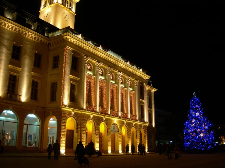 an exterior view of buildings with a lit up christmas tree in the middle