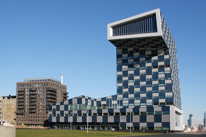 a checkered building sitting in front of tall buildings