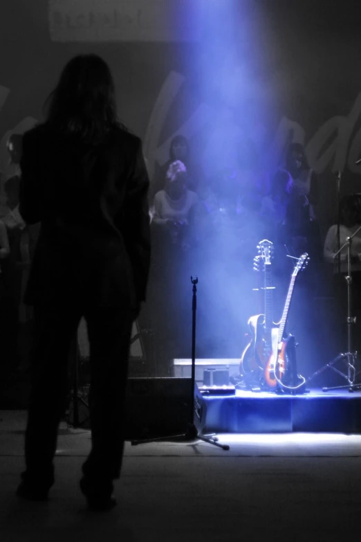 a band performing on stage with blue lights shining