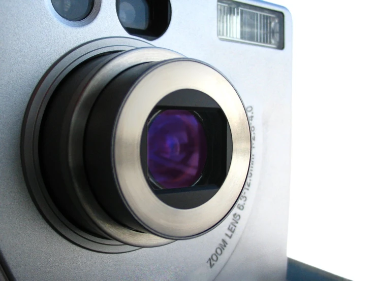 a silver and black camera with blue reflection