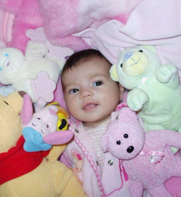 a baby surrounded by various stuffed animals
