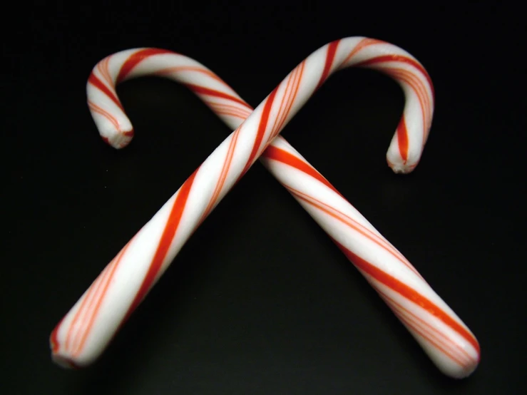 a red and white candy cane sits on top of it's side