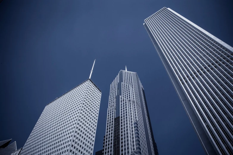 looking up at the bottom of three large buildings