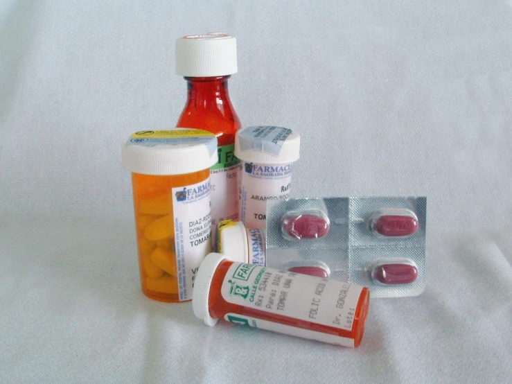 three medicine bottles sitting on top of a white cloth