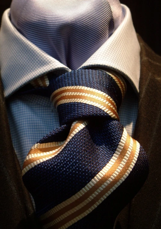 a suit and tie have two brown, white, and blue stripes