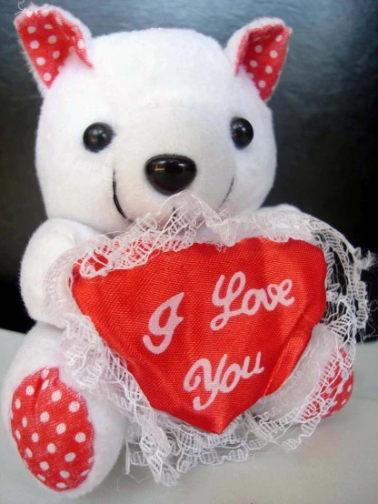 there is a white stuffed bear holding a heart
