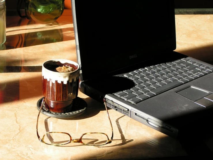 coffee cup in front of laptop computer on table
