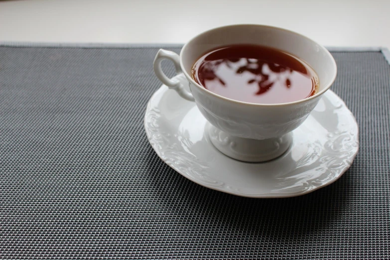 a cup with liquid sitting on a saucer