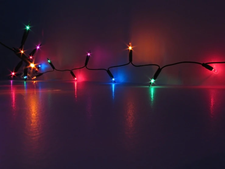 a colorful display of lights on water with reflection