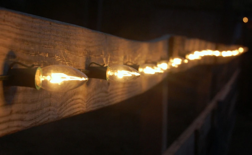 a wooden plaque with several lights glowing down on it