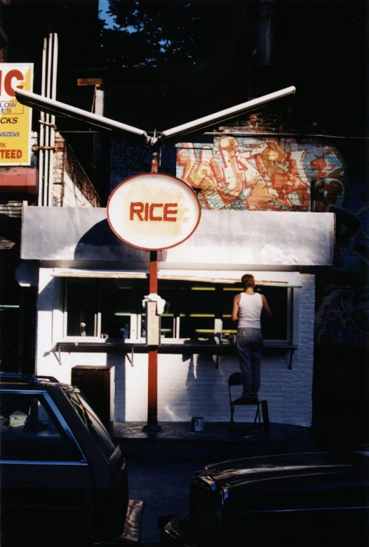 a person standing next to a building under streetlights