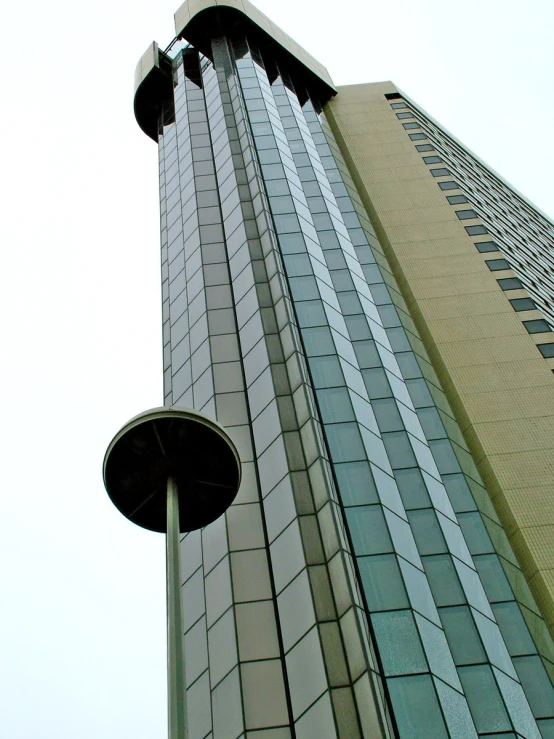 looking up at the top of the tower with a bird perched on the side