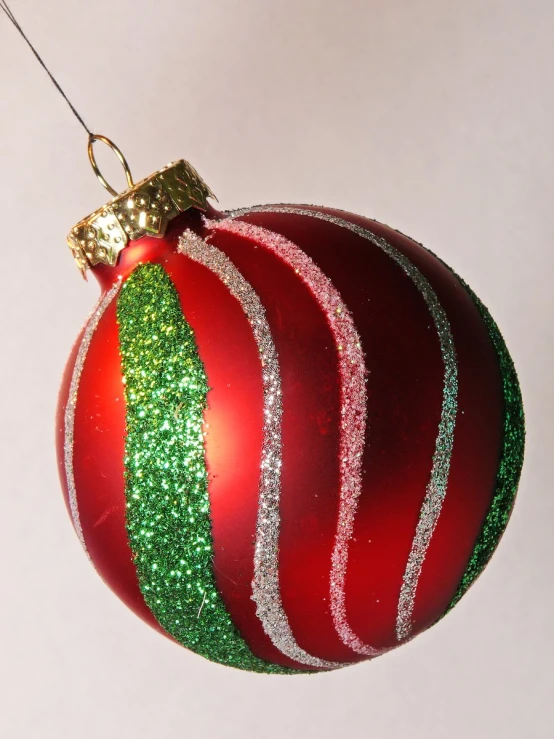 an ornament with a red and green ribbon