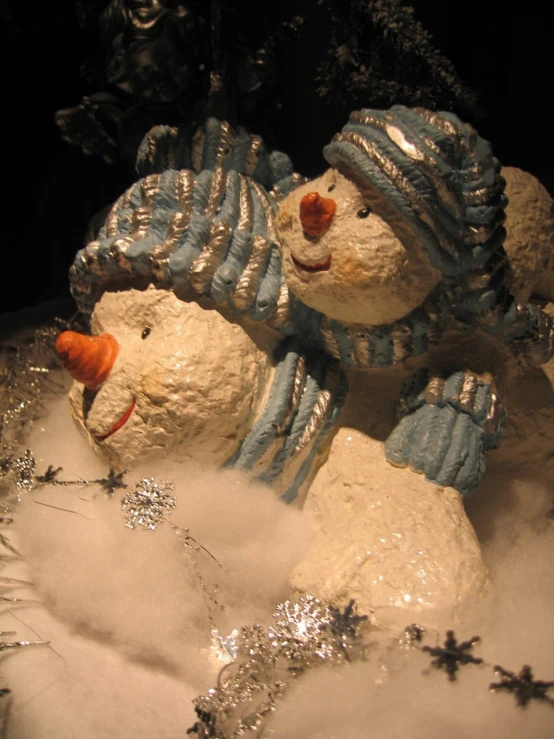 a snow man and snowdog statue sitting next to each other