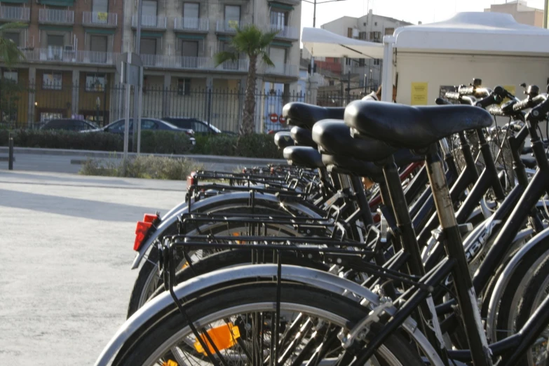 bikes are lined up along the sidewalk next to some buildings