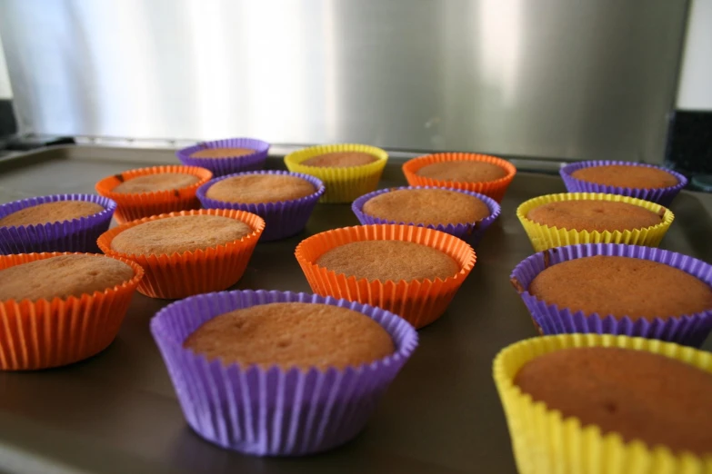 a bunch of muffin cups lined up in different colors