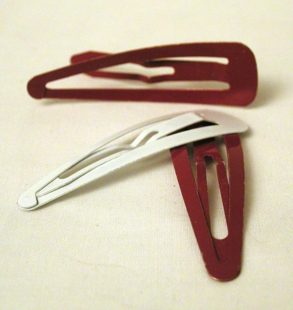 two red and white scissors on a white surface
