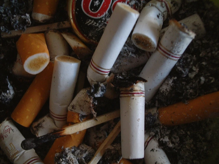 a large pile of cigarettes with various burnt ones