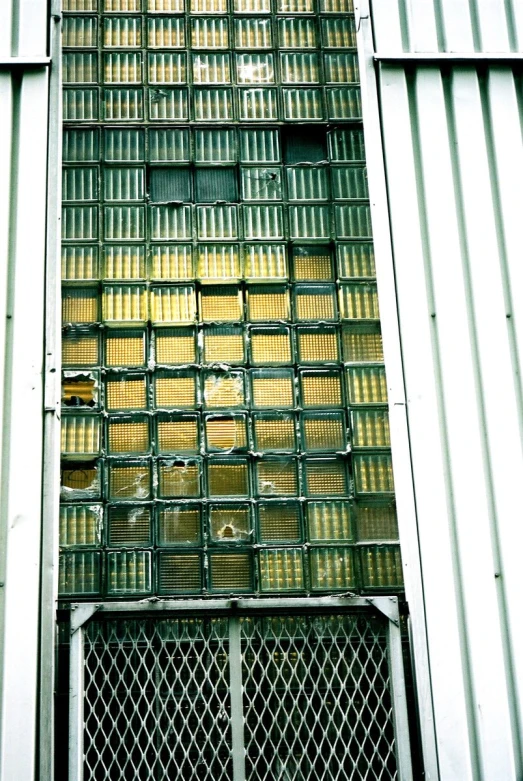 a metal gate sits against a gray metal building