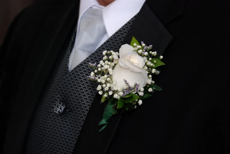a man is dressed in black with a boutonniere