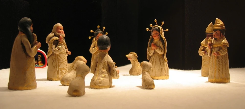 a collection of little figurines standing on top of a white surface