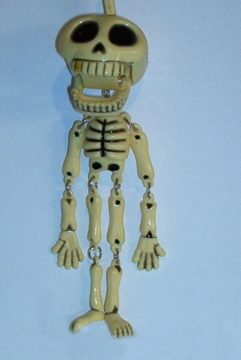 a skeleton holding a key chain that has a skull on it