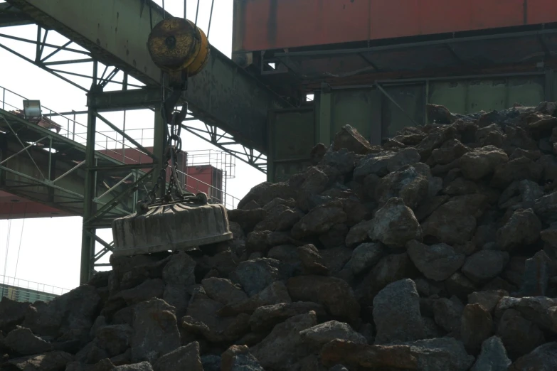 large pile of rock sitting under a crane