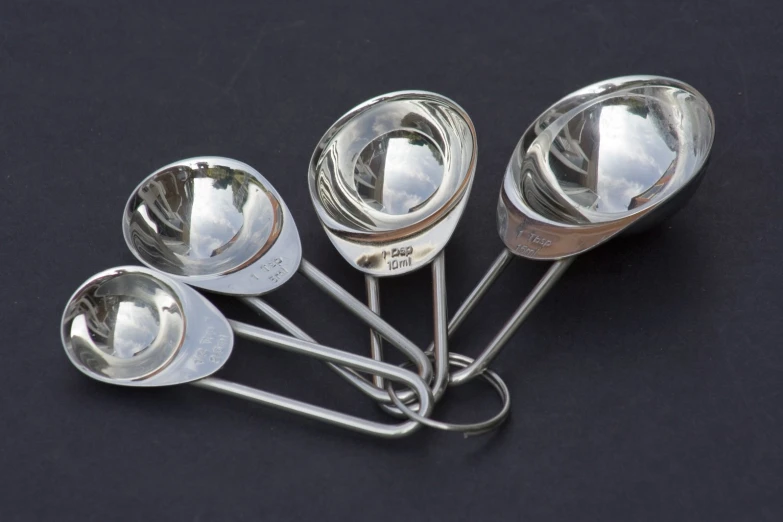 the spoons and other kitchen utensils have reflections of sky in them